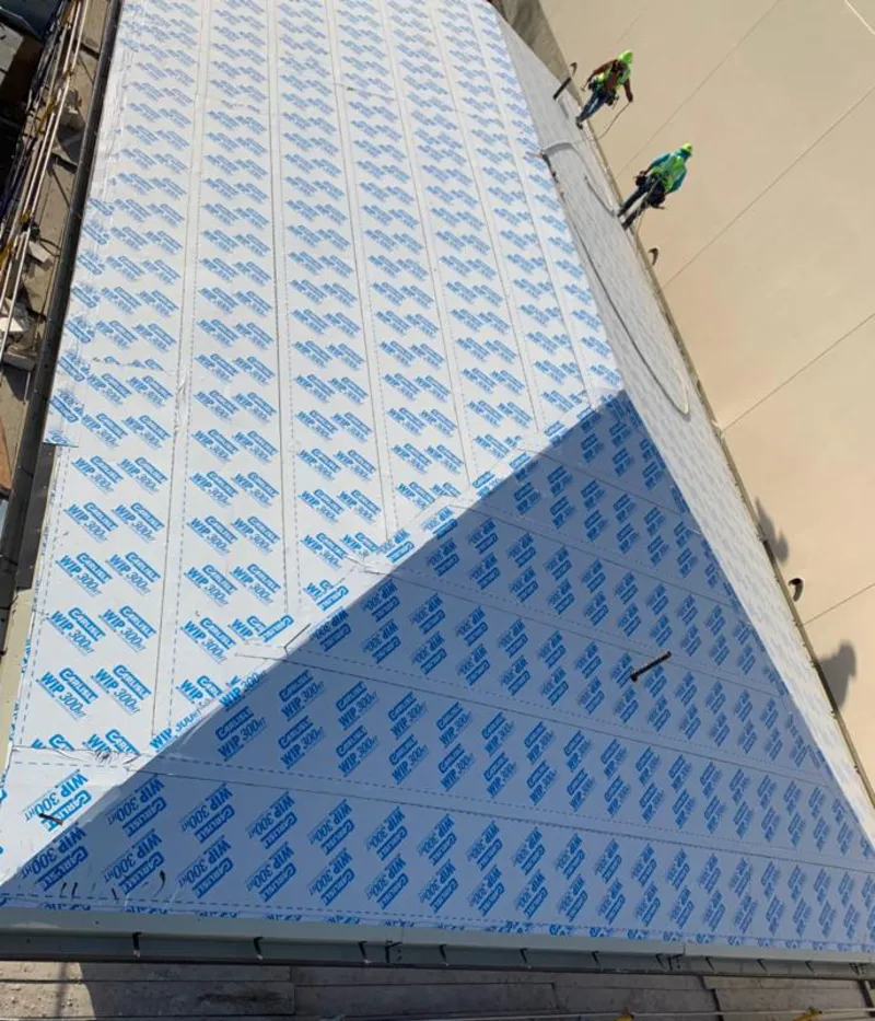 Professional roofers installing underlayment on a metal roof in Huntingburg